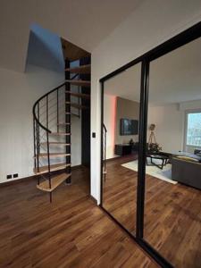 - un salon avec un escalier en colimaçon dans une maison dans l'établissement Loft moderne dominant la cathedrale, à Limoges