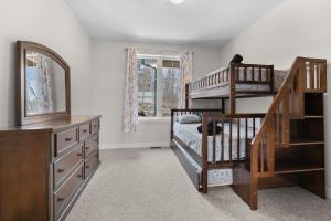 a bedroom with a bunk bed and a staircase at Muskoka Retreat Stunning Hilltop Views in Huntsville