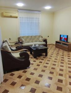uma sala de estar com um sofá e uma mesa em Pink house em Lankaran