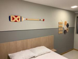 a bedroom with a bed with a baseball bat on the wall at 4 Suítes Pé na Areia Itacimirim in Camacari