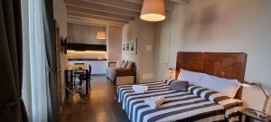 1 dormitorio con 1 cama con manta a rayas en Balbianino, en Lenno