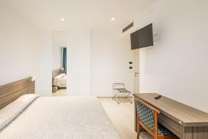 1 dormitorio con 1 cama y TV en la pared en Hotel Nuova Grottella, en Copertino