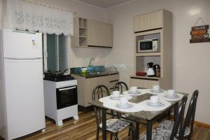 康科迪亞的住宿－Casa com estacionamento no centro，厨房配有桌椅和白色冰箱。