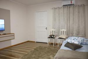 康科迪亞的住宿－Casa com estacionamento no centro，一间卧室设有一张床、一台电视和一个窗口。