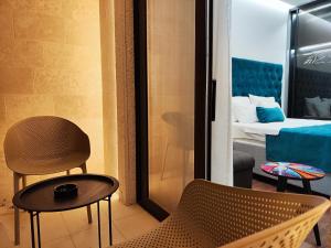 a room with a chair and a bedroom with a bed at Lolo Luxury rooms & suites in Budva