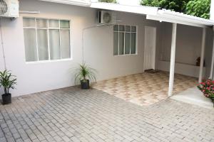 a white house with two potted plants in front of it at Casa com estacionamento no centro de Concórdia SC in Concordia +19 photos