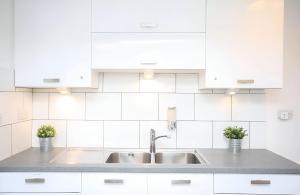 a kitchen with white cabinets and a sink at New Modern Room With En Suite Park Street Room 2 in Luton