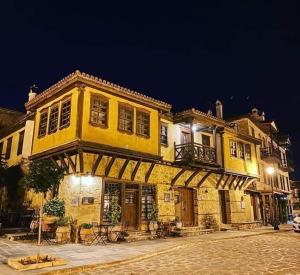 a large yellow building on a street at night at Aristotelous Alexandrou Historic Inn in Arnaia