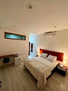 1 dormitorio con 1 cama grande y escritorio en Bistu Hotel - Vila Nova Conceição, en São Paulo