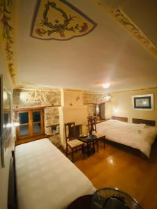 een slaapkamer met 2 bedden en een stenen muur bij Aristotelous Alexandrou Historic Inn in Arnaia