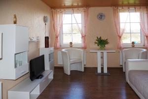 sala de estar con sofá y TV en Ferienwohnung Fehse, en Kalbe