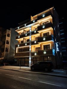 een auto die 's nachts voor een gebouw geparkeerd staat bij Lolo Luxury rooms & suites in Budva