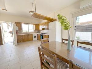 a kitchen with a table and a vase with a plant at Sunset Pearl Holiday Villa in Ayia Napa