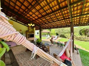 a woman laying on a hammock in a patio at Pousada Chalés Jardim das Bromélias - Visconde de Mauá in Visconde De Maua