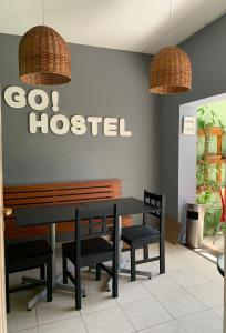 a restaurant with a black table and chairs and a sign at Go Hostel in Córdoba