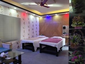 a room with two beds and a table in it at Spas Personal Care in Dhaka