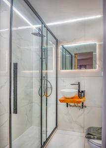 a bathroom with a glass shower and a sink at Sunny Palm Room Crete in Rethymno Town