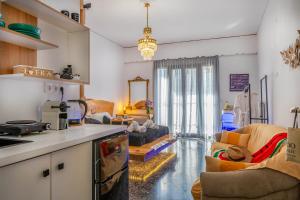 a kitchen and a living room with a couch at Sunny Palm Room Crete in Rethymno