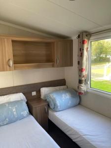 プスヘリにあるHafan Y Mor 5 Lakeside , 3 Bedrrom Deluxe sleeps 8のベッドが2つと窓がある小さな部屋