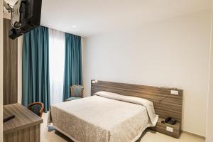 a hotel room with a bed and a table and a window at Hotel Nuova Grottella in Copertino +26 photos
