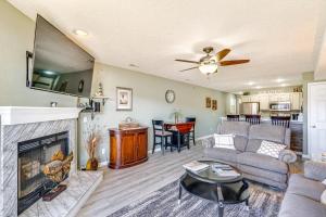 a living room with a couch and a fireplace at Lakefront Osage Beach Condo with Pool Access! in Osage Beach
