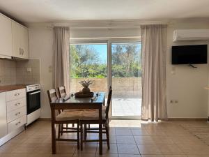 a kitchen with a table and chairs and a window at Corfu Lakeside Cottage in Kanoni
