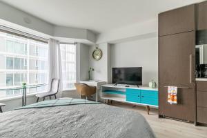 a bedroom with a bed and a desk and a tv at 19th Fl Modern Studio in Yorkville in Toronto