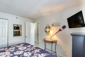 a bedroom with a bed and a tv on a wall at Lakefront Osage Beach Condo with Pool Access! in Osage Beach