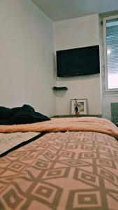 um quarto com uma cama e uma televisão na parede em PEACE em Marselha