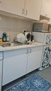 uma cozinha com armários brancos e um lavatório em PEACE em Marselha