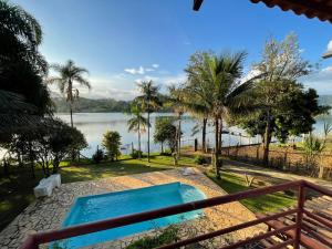 uma piscina com vista para a água em Casa do Lago - Mar de Minas - Lago de Furnas em Carmo do Rio Claro