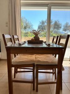 a dining room table with chairs and a window at Corfu Lakeside Cottage in Kanoni +22 photos