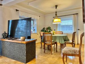 a living room with a large television and a table at Privathaus Sieglinde in Nußdorf