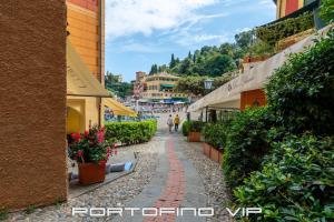 une rue pavée dans une ville avec des bâtiments et des fleurs dans l'établissement King's House by PortofinoVip, à Portofino