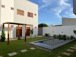 a house with a swimming pool in the yard at Marbello Pousada Gostoso in São Miguel do Gostoso
