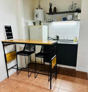 a kitchen with a table and chairs and a refrigerator at Monoambiente/Studio Avenida Gaona Ramos Mejía in Ramos Mejía