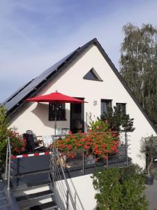 フラインスハイムにあるFerienwohnung im Haus Petryの白い家 赤い傘付きのバルコニー付