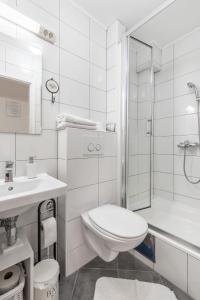 a white bathroom with a toilet and a shower at Apartments and Rooms Petra in Split