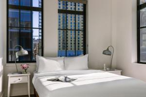 a bedroom with a white bed with two windows at Sonder Dovetail in Nashville