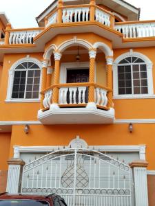 uma casa laranja com uma varanda em Cas Bed and Breakfast em Corral Spring