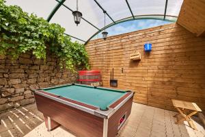 een pooltafel in een tuin met een houten muur bij Laouen Blavezh'ti in Saint-Barthélemy