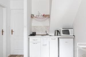 cocina blanca con fregadero y microondas en Apartments and Rooms Petra, en Split