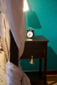 einen Wecker auf einem Tisch neben einem Bett in der Unterkunft Vakantiewoning Buit&Rijk in Tongeren