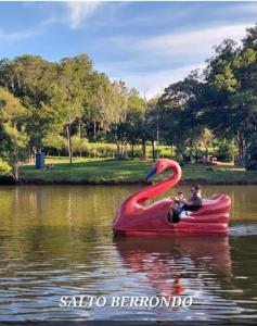 a child riding a pink flamingo raft in the water at Casa 2 dormitorios in Oberá