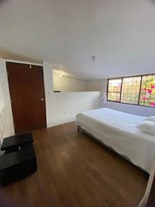 een slaapkamer met een groot bed en 2 ramen bij VEGAN ROOM in Barranquilla