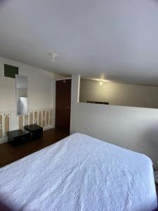 een slaapkamer met een wit bed en een spiegel bij VEGAN ROOM in Barranquilla