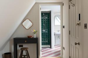 a stairway with a bathroom with a sink and a stool at The Penn in Windermere