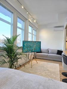 a living room with a couch and a tv at Upea asunto Salon sydämessä, Ilmainen pysäköinti, lähellä kaikkea in Salo