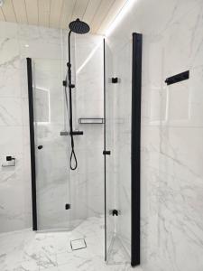 La salle de bains est pourvue d'une douche avec une porte en verre. dans l'établissement Upea asunto Salon sydämessä, Ilmainen pysäköinti, lähellä kaikkea, à Salo