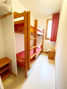 Двухъярусная кровать или двухъярусные кровати в номере Appartement Ski Pied de Pistes - Valfréjus